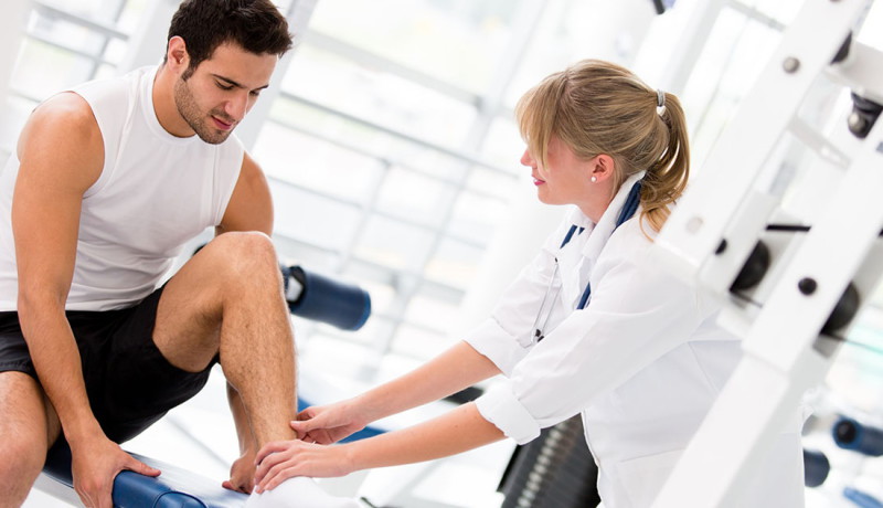 Male-getting-ankle-examined